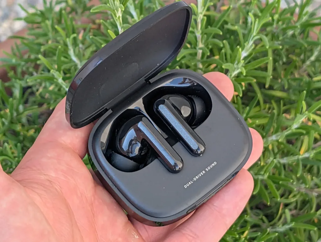 xiaomi redmi buds 6 otevrena krabicka v ruce zelena rostlina